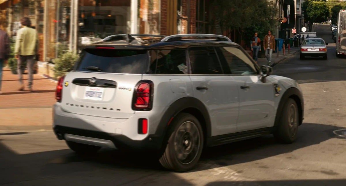 The MINI Cooper SE Countryman PHEV turning a corner in the city. Flow MINI in Winston-Salem NC